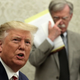 President Donald Trump speaks to members of the media as former National Security Adviser John Bolton listens.